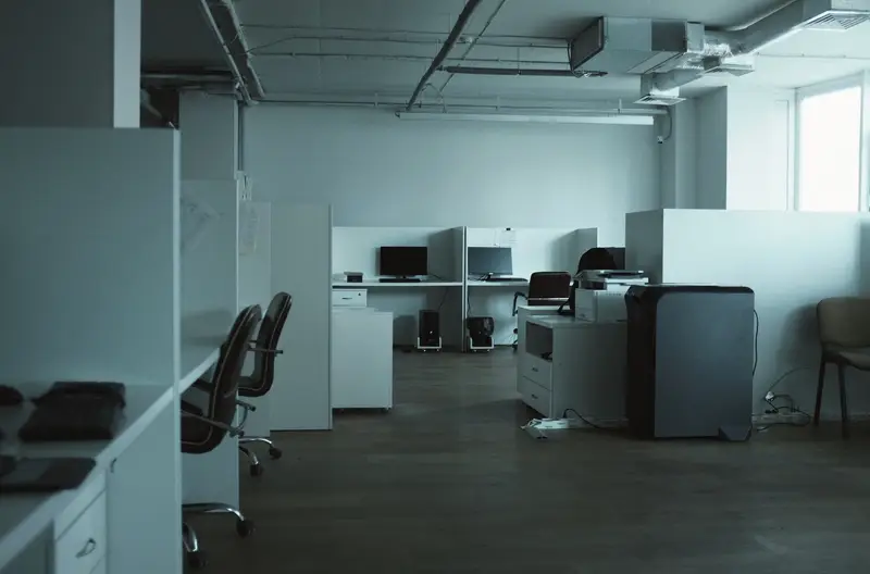 An open-plan office with empty desks and chairs
